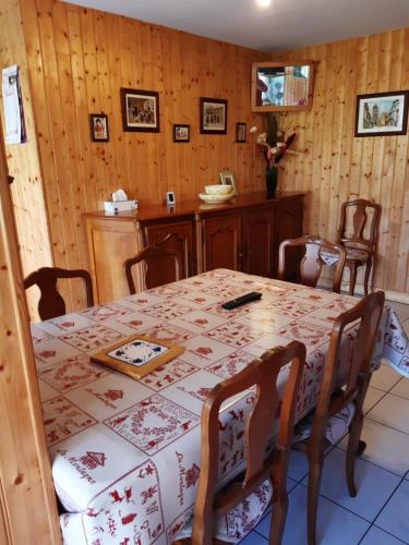 d'une salle à manger avec une table, des chaises et des murs en bois. dans l'établissement Les Angéliques, à Gérardmer