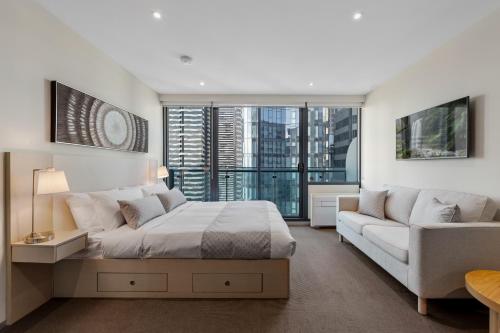 sypialnia z dużym łóżkiem i kanapą w obiekcie City Stays w Melbourne