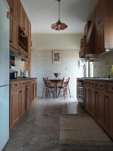 a kitchen with wooden cabinets and a table at Summer Breeze Villa in Saronic Gulf in Anavyssos