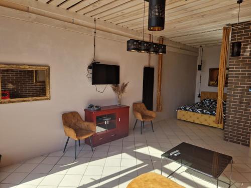 a living room with a tv and a bed at WILLA VASCO KAPITAN in Rewa