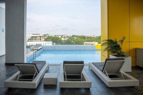 ein Zimmer mit 2 Stühlen und einem Pool in der Unterkunft Labone Finest 2 Bed in Accra