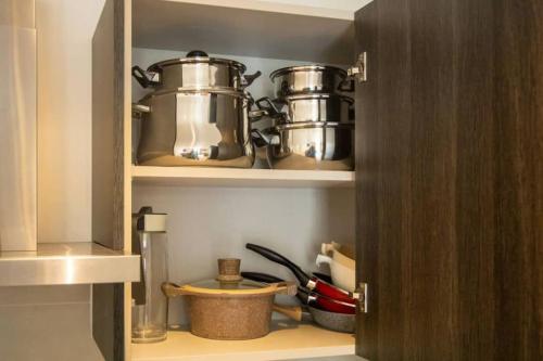 a kitchen with two pots and pans on a shelf at Labone Finest 2 Bed in Accra