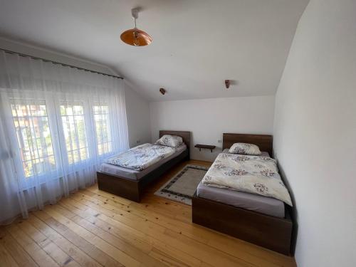 a bedroom with two beds and a window at Qendresa Apartments in Prishtinë