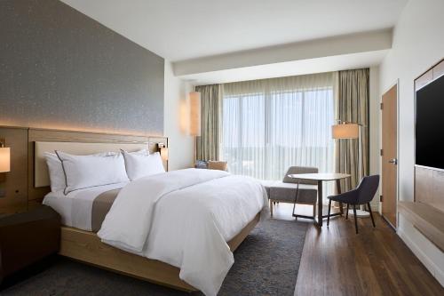 a hotel room with a large bed and a table at The Westin Raleigh-Durham Airport in Raleigh