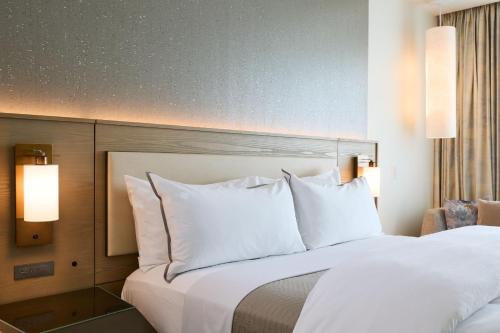 a hotel room with a bed with white pillows at The Westin Raleigh-Durham Airport in Raleigh