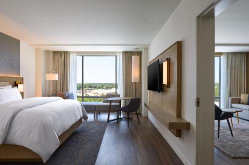 a hotel room with a bed and a desk and a television at The Westin Raleigh-Durham Airport in Raleigh