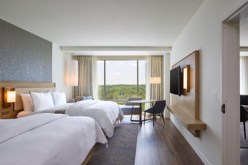 um quarto de hotel com duas camas e uma televisão em The Westin Raleigh-Durham Airport em Raleigh