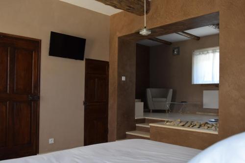 a bedroom with a bed and a bathroom with a tub at Résidence hôtelière et SPA des sources du gros noyer in Malaucène
