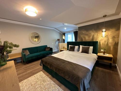 B59 BOUTIQUE HOTEL في كامبولونغ مولدوفينيسك: غرفة نوم بسرير كبير واريكة خضراء