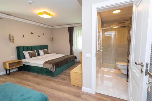 um quarto com uma cama, um chuveiro e um WC em B59 BOUTIQUE HOTEL em Câmpulung Moldovenesc