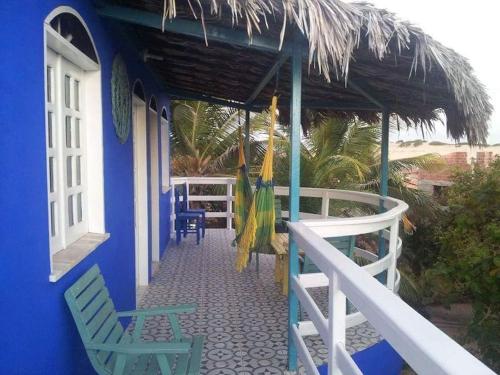 a blue building with two chairs and a umbrella at Charming blue house with kitchen parking and garden in Canoa Quebrada