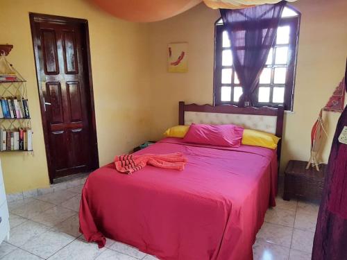 um quarto com uma cama grande e um cobertor vermelho em VILLA com Wi-Fi, cozinha, parking, Canoa Quebrada zona centro, jardim tropical, tudu prossimo a pe em Canoa Quebrada