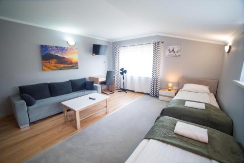 sala de estar con 2 camas y sofá en Gasthaus, en Bielsko-Biala
