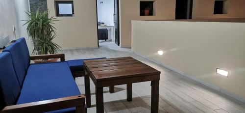 a living room with a table and a blue couch at Situación inmejorable. Céntrico y tranquilo in Carrizal