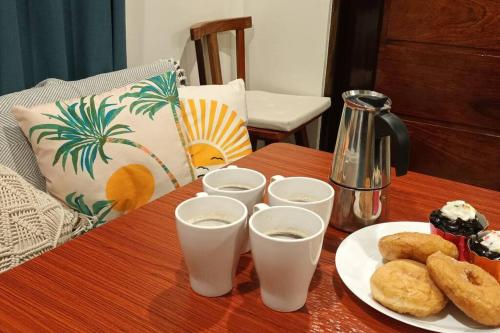 einen Tisch mit einem Teller Essen und Gläsern Milch in der Unterkunft Tiny Hideaway Mutya House with free 2 scooters in El Nido