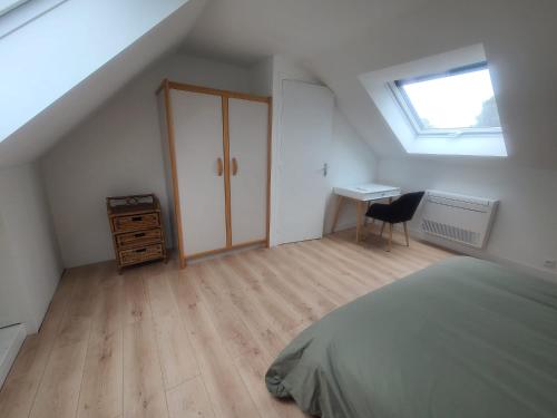 Dormitorio en el ático con cama y escritorio en Suites villa à 25km de Paris idéal JO, en Voisins-le-Bretonneux