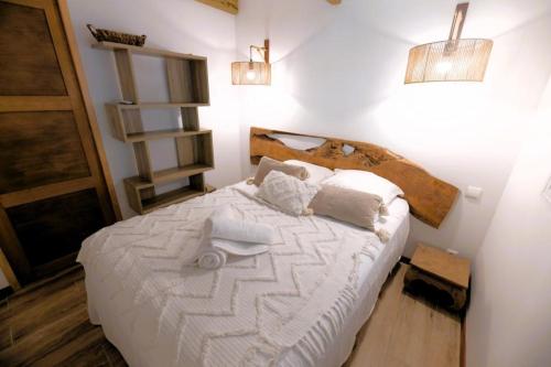 1 dormitorio con 1 cama con sábanas y almohadas blancas en Le Loys Martinique en Sainte-Anne