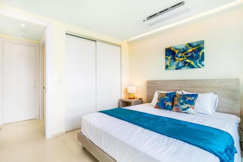 a bedroom with a large bed with blue and white sheets at Luxury Oceanview 1BR on beach in Cupecoy