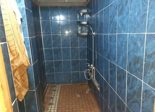 a blue tiled shower with a blue tiled wall at Jumaboy Guesthouse 