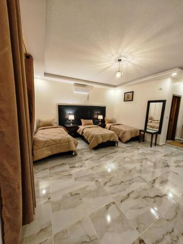 a large room with two beds and a stone floor at iHome Petra in Wadi Musa