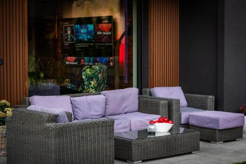 two wicker chairs with purple pillows and a table at Dom z basenem Bałtów 22 in Bałtów