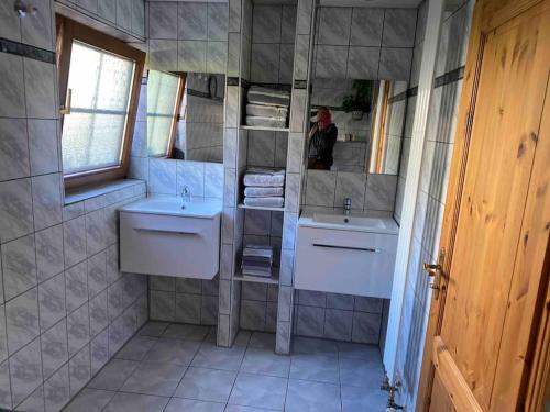 a bathroom with two sinks and a mirror at Ferien auf dem Eliesenhof in Welzheim