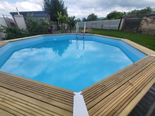 uma grande piscina azul com um deque de madeira em Chalupa Oslany em Oslany