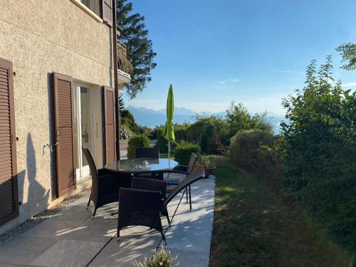a patio with a table and chairs on it at Lakeview Apartment-Lavaux in Grandvaux
