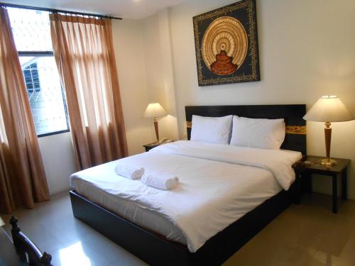 The Bang Khun Phrom Suites tesisinde bir odada yatak veya yataklar