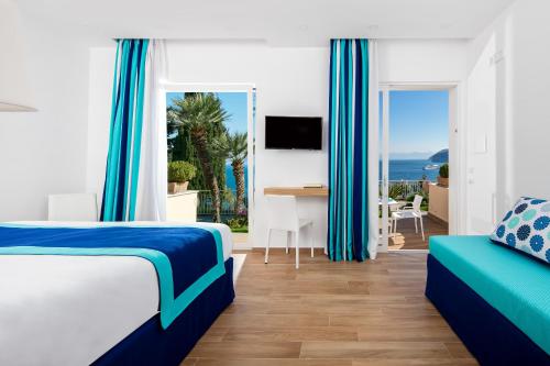 a bedroom with a bed and a view of the ocean at Hotel Miramare in Sorrento