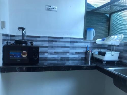 Kepala BatasにあるLaman Norras Homestayのキッチン(電子レンジ、シンク付)