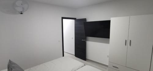 a bedroom with a tv and a white cabinet at Situación inmejorable. Céntrico y tranquilo in Carrizal