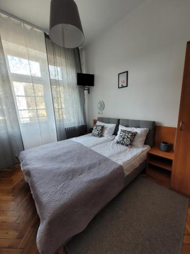 1 dormitorio con 2 camas y ventana grande en Zajazd Meran, en Krynica-Zdrój