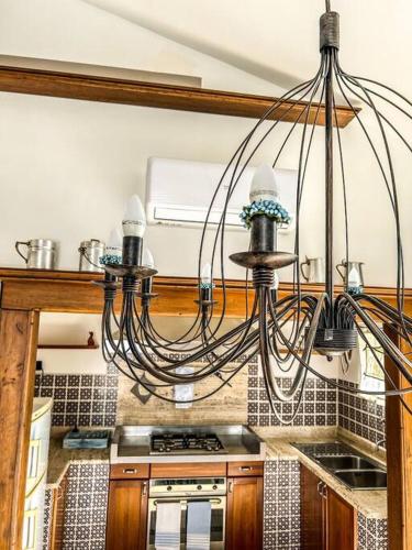 a kitchen with a chandelier hanging over a stove at Casetta della Muri in Isola delle Femmine