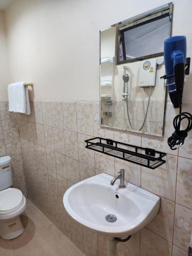 a bathroom with a sink and a mirror and a toilet at The Travellers House - Pet Friendly Accommodation in Bangkok