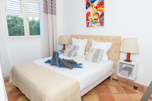a bedroom with a large white bed with two lamps at Villa Devaki in Saint-François