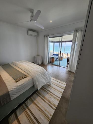 Schlafzimmer mit einem Bett und Meerblick in der Unterkunft Rocky Bay on the View in Gordonʼs Bay