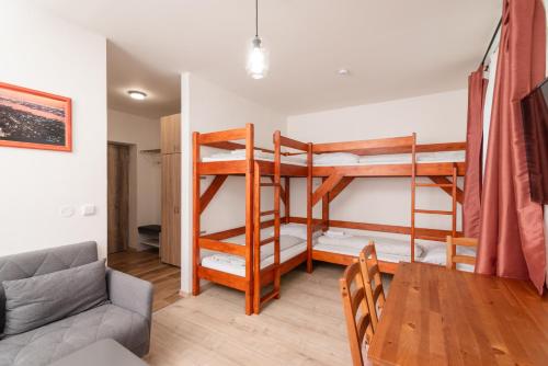 a living room with two bunk beds and a table at HK apartments by Správa ubytka in Rokytnice nad Jizerou