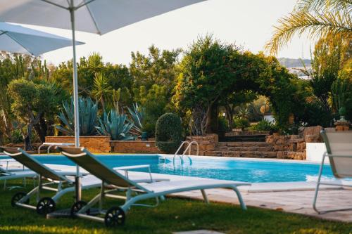 een zwembad met 2 stoelen en een parasol bij Emesh Boutique Suite in Agrigento