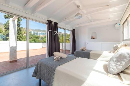 a bedroom with two beds and a large window at Villa Los Tres Almendros in Marbella