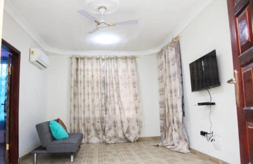 a living room with a couch and a television at CNC Rehoboth Villa in Accra