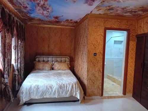 - une chambre avec un lit et un plafond fleuri dans l'établissement Victorus Homes, à Freetown
