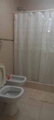 a bathroom with a toilet and a shower curtain at Lo de Elena in Ushuaia