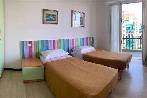 two beds in a room with a rainbow wall at Vista mare con ogni comfort in Varazze