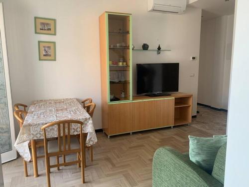 a living room with a table and a flat screen tv at Vista mare con ogni comfort in Varazze