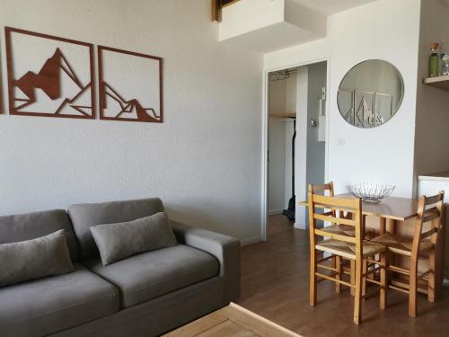 un salon avec un canapé et une table dans l'établissement Duplex avec vue lac, résidence la Singlantane, aux Angles