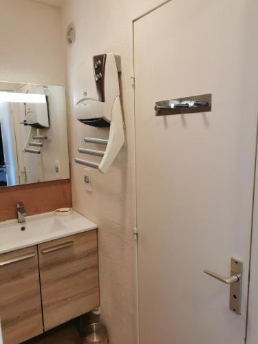 La salle de bains est pourvue d'un réfrigérateur blanc et d'un évier. dans l'établissement Duplex avec vue lac, résidence la Singlantane, aux Angles