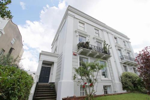 a white building with a staircase in front of it at Stunning Arty Apartment in the heart of Clifton in Bristol