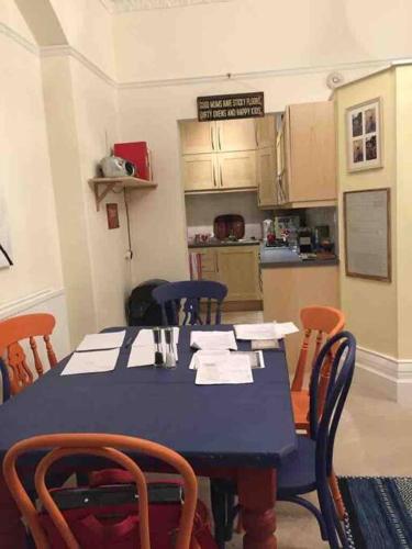 a dining room with a blue table and chairs at Stunning Arty Apartment in the heart of Clifton in Bristol
