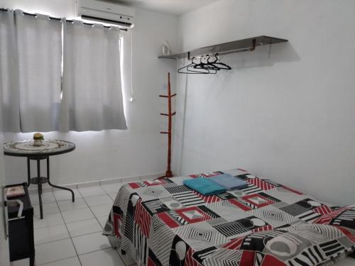 een slaapkamer met een bed en een tafel. bij Casa pertinho da praia in Paulista